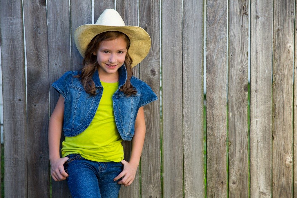 cowgirl posing on wooden fence