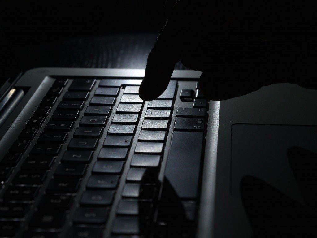 Identity theft - one finger shadow on keyboard