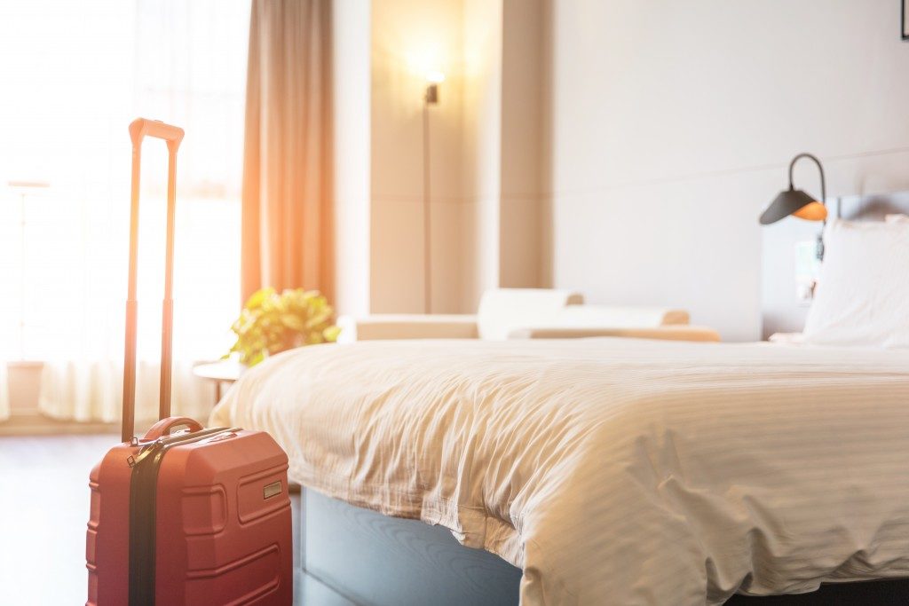 Luggage next to bed in guest room