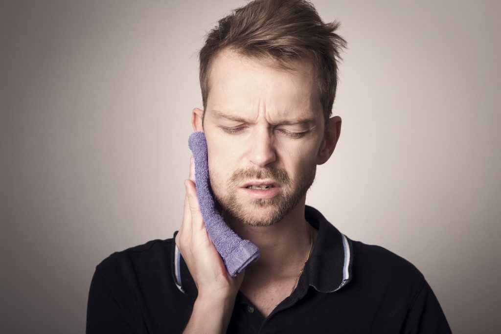 Man experiencing pain from wisdom tooth removal