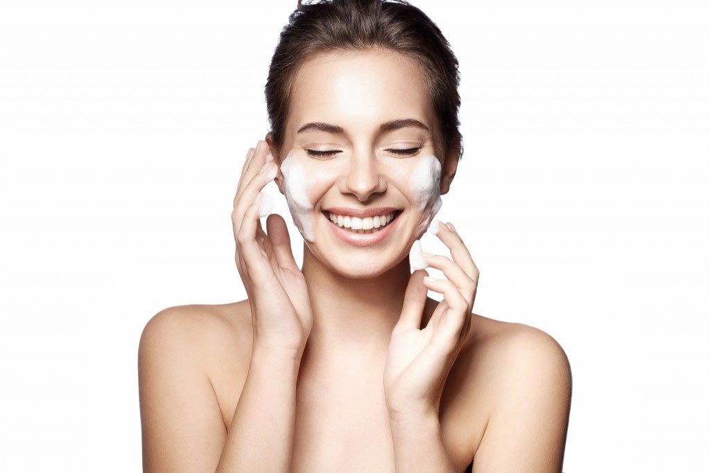 Woman happy cleanses the skin on a white background isolated