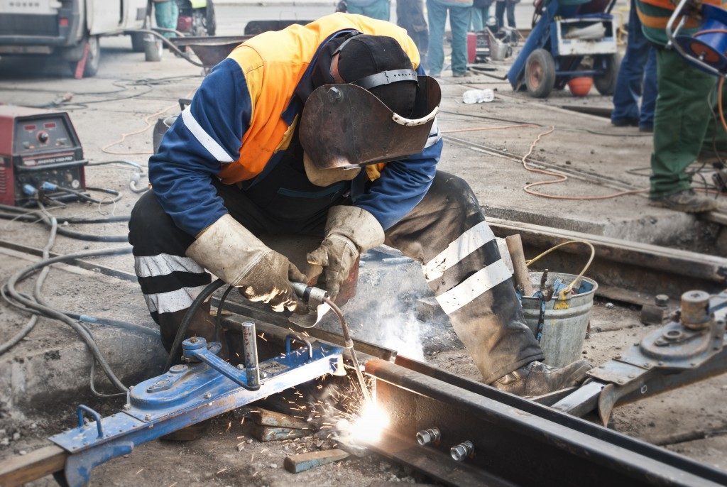 man wearing safety equipment while welding