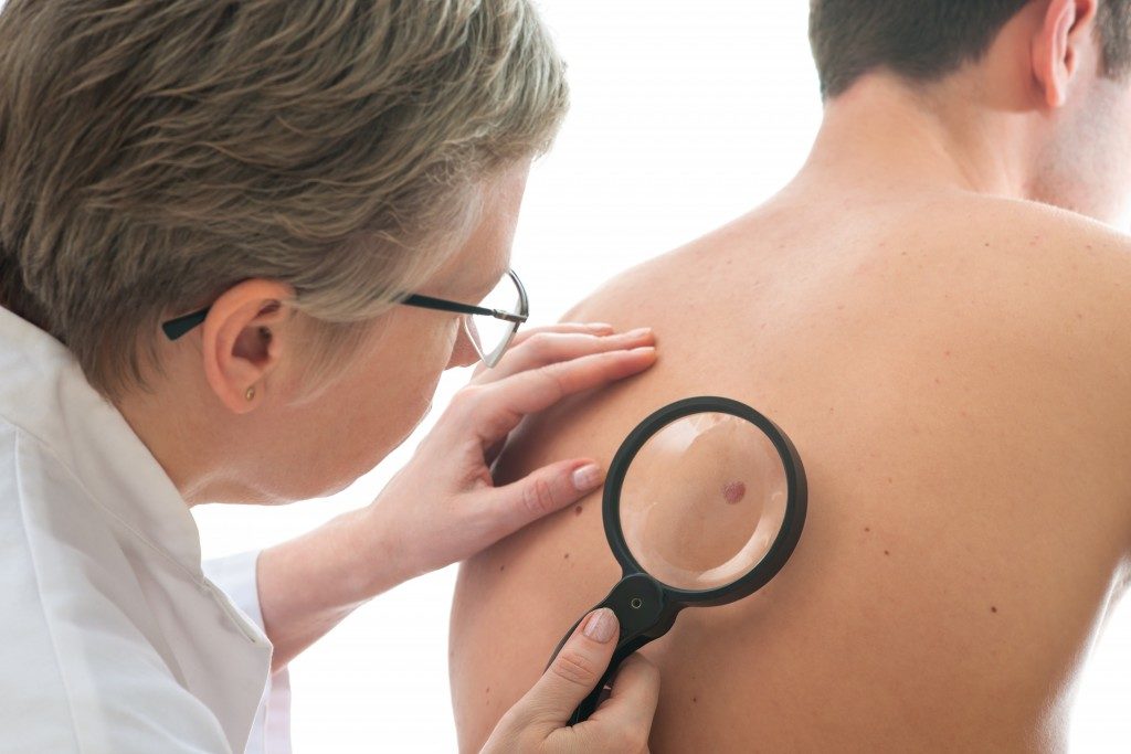 Dermatologist checking skin of patient