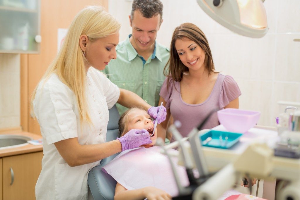 child at the dentist with her parents