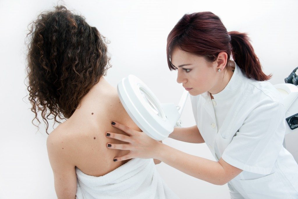dermatologist doctor inspecting woman skin