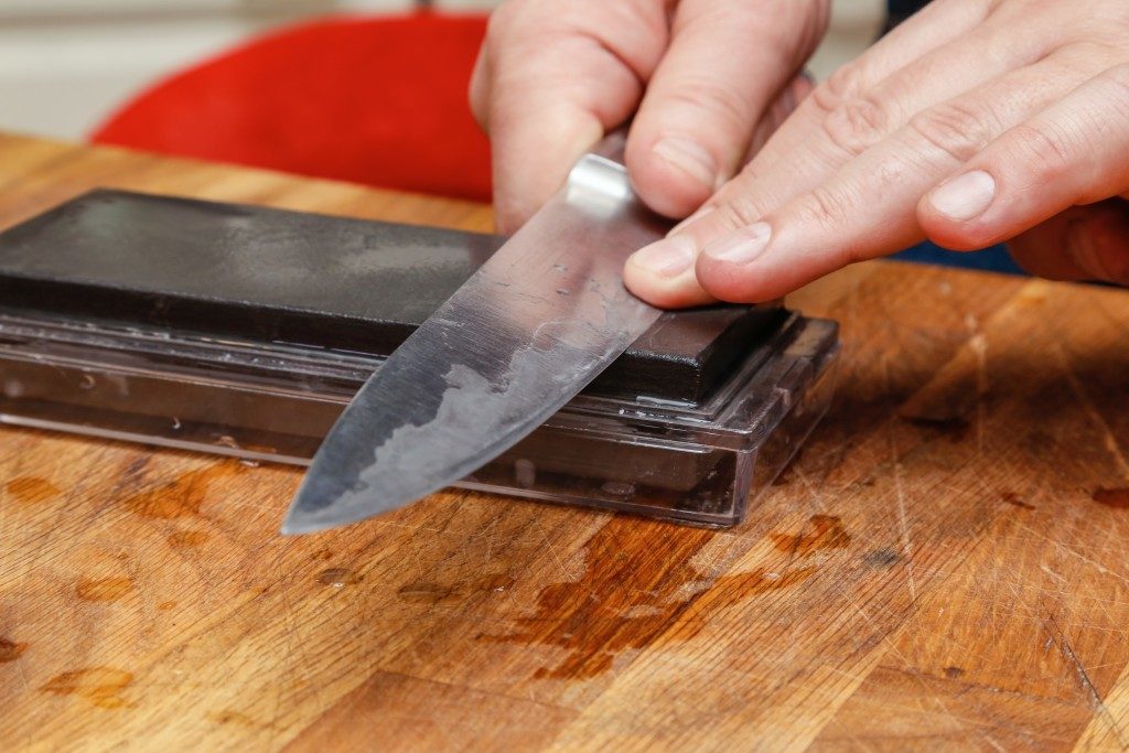 person sharpening their knife