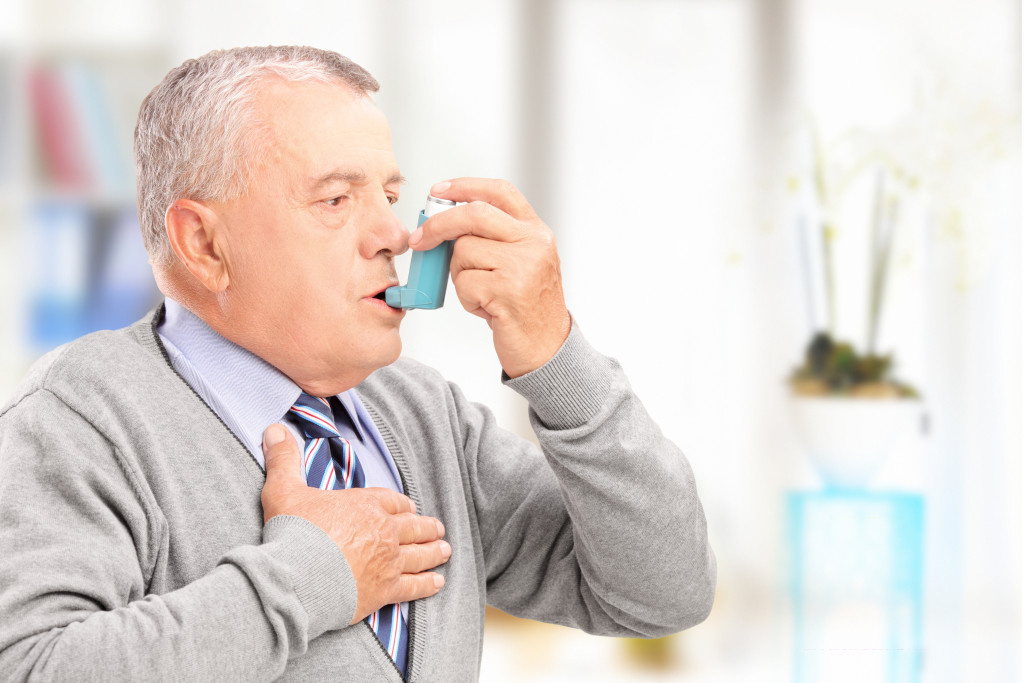elderly man taking an inhaler