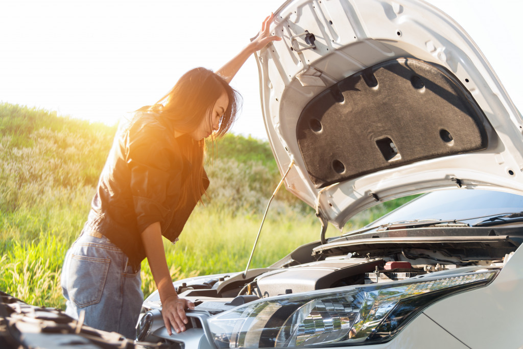 woman checking car engine