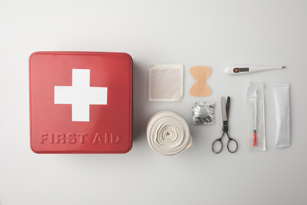 Red color first aid box with bandage and other items