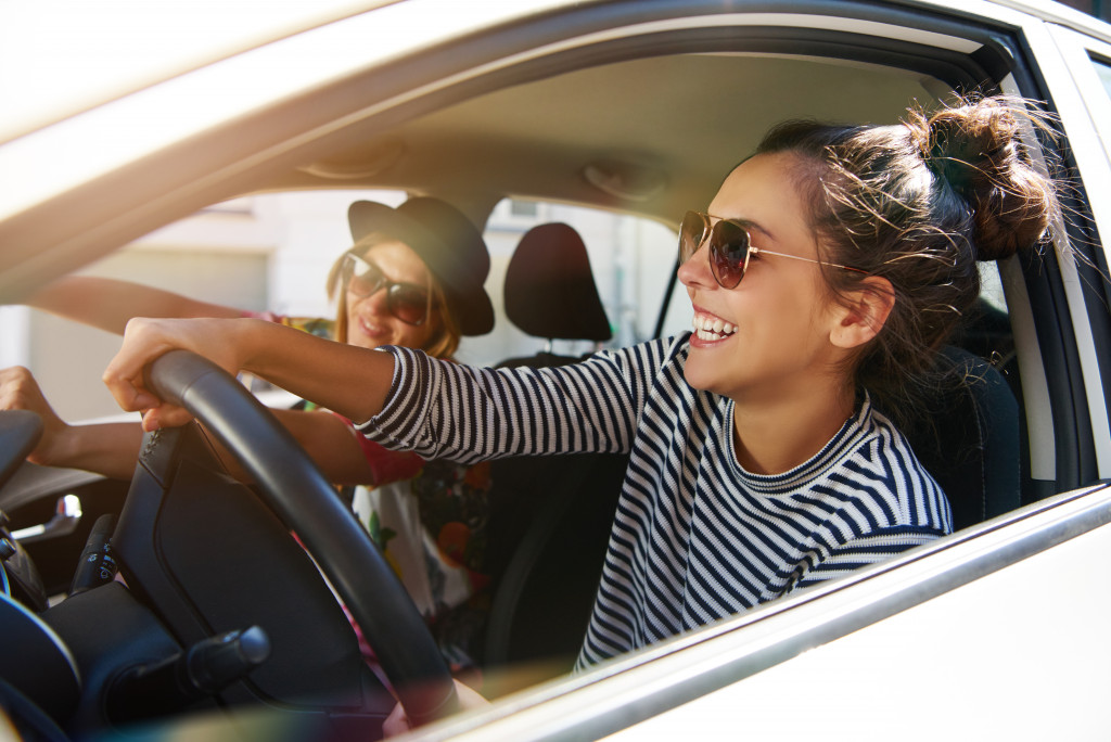 two young women wearing sunglasses and having fun