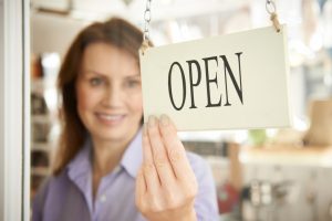 store owner turning the open sign on the stop