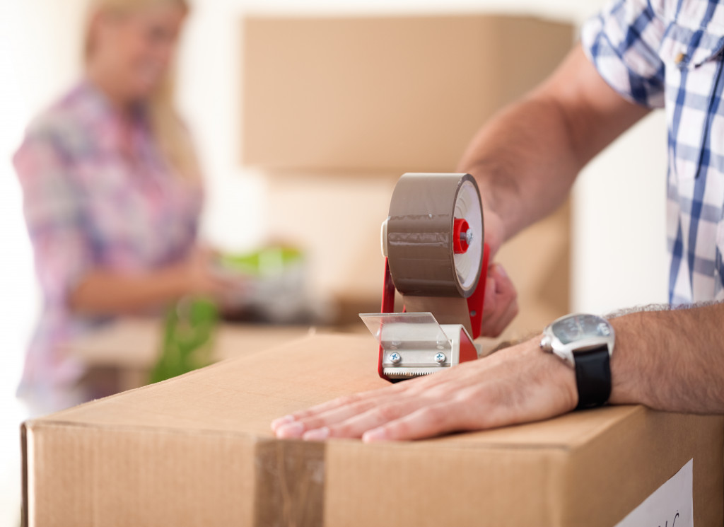 Close up of male hand packing cardboard box