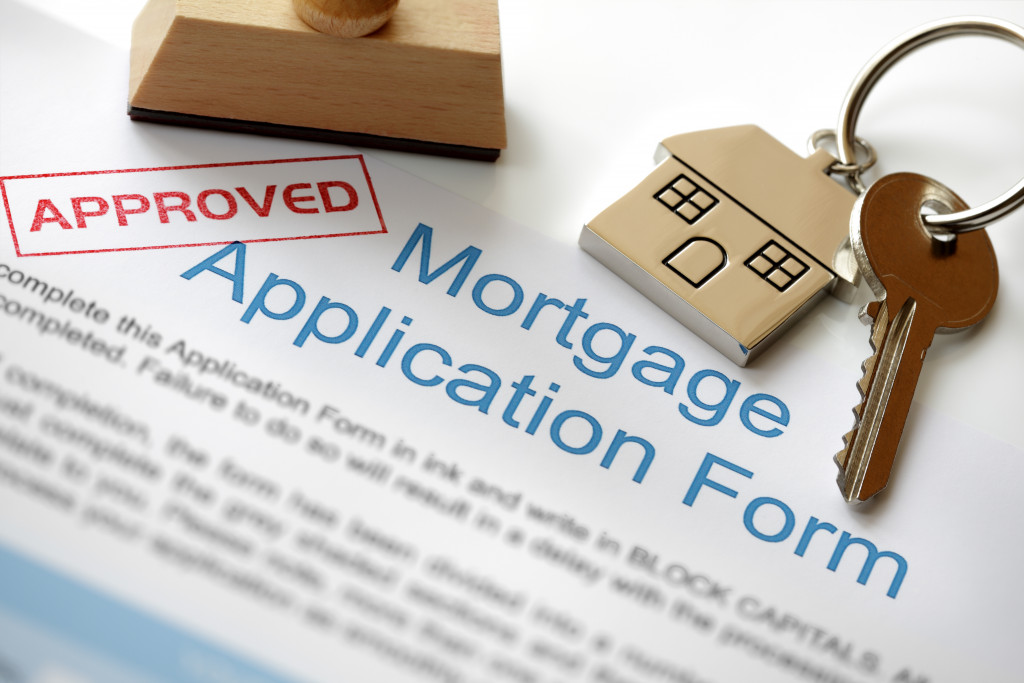 An approved mortgage application with house key and rubber stamp