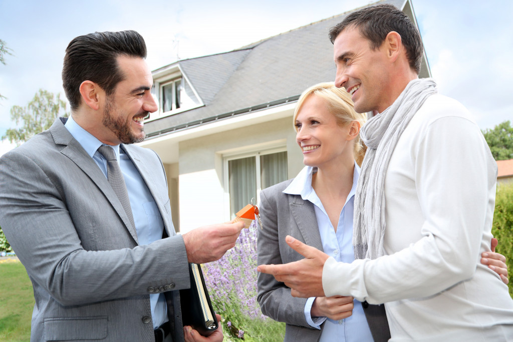 A real estate agent giving the keys to a new home to a couple