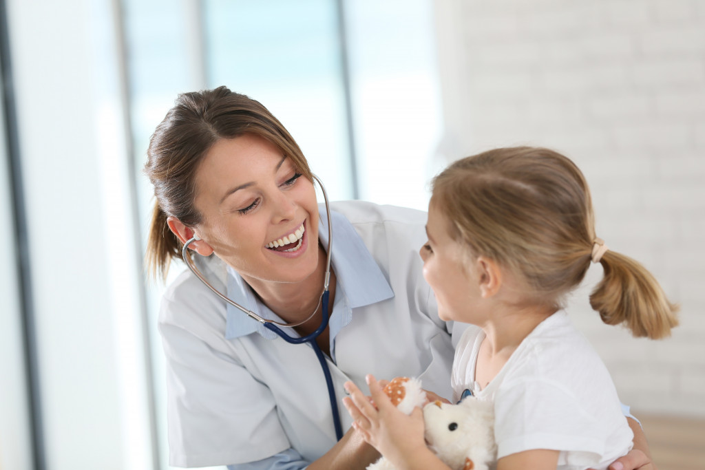 smiling female doctor talking to a young girl